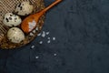 Three Quail Eggs And The Wooden Spoon Placed  On The Cork Supply. Slate Black Uneven Stone Background. Close Up. Top View. Free Royalty Free Stock Photo