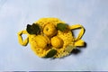 Three quince apples on yellow mesh bag