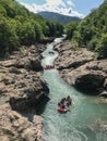 three rafts move quickly along a narrow river in the mountains.