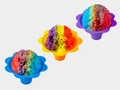 Three rainbow Hawaiian shave ice, shaved ice or snow cone desserts in a row against a white background.