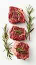 Three raw beef steaks with rosemary and pepper on a white background, culinary preparation concept Royalty Free Stock Photo