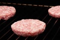 Raw hamburgers cooking on grill Royalty Free Stock Photo