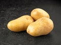 Three raw potatoes on grey Royalty Free Stock Photo