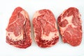 Three raw Rib eye steaks on a white background. Food concept. Aerial view Royalty Free Stock Photo