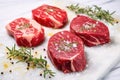 three raw steaks garnished with herb rub on marble slab Royalty Free Stock Photo