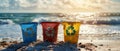 Three recycle bins on a sandy beach, with the ocean in the background Royalty Free Stock Photo