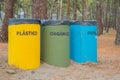 Three recycle bins between trees Royalty Free Stock Photo