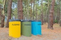 Three recycle bins between trees Royalty Free Stock Photo
