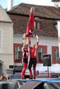 Three red acrobats on a trampoline