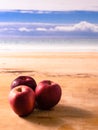 Three red apples on the background of the sea Royalty Free Stock Photo