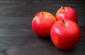 Three red apples on dark colored wooden table with free space for text and design Royalty Free Stock Photo