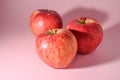 three red apples on a pink background 6 Royalty Free Stock Photo