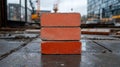 Three red bricks stacked on a wet construction site. Royalty Free Stock Photo