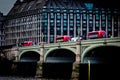 Three red buses crossing westminster bridge