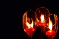 Three red candle lights in glasses on black background. Concept of Holiday Season and memory Royalty Free Stock Photo