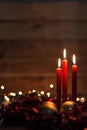 Three red candles with Christmas balls and dark background with lights Royalty Free Stock Photo