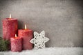 Three red candles on gray background, Christmas decoration. Advent mood.