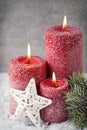 Three red candles on gray background, Christmas decoration. Advent mood. Royalty Free Stock Photo