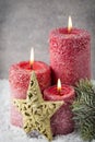 Three red candles on gray background, Christmas decoration. Advent mood. Royalty Free Stock Photo