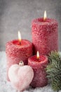 Three red candles on gray background, Christmas decoration. Advent mood. Royalty Free Stock Photo