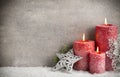 Three red candles on gray background, Christmas decoration. Advent mood. Royalty Free Stock Photo