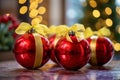 three red christmas balls with yellow ribbons on a table