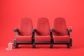 Three red cinema chairs on red