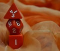 Three red dice and an orange scarf