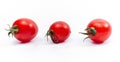 Three red fresh tomatoes with green leaf and water drops. White background, isolated. Close-up Royalty Free Stock Photo