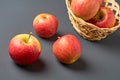 Three red fresh whole ripe apples with vitamins on background of full wooden wicker basket Royalty Free Stock Photo