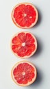 three red fruit slices on a white background