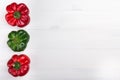 Three red and green peppers on a white wood background Royalty Free Stock Photo