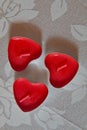 Three red heart shaped candles on the white table, top view Royalty Free Stock Photo