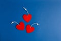 Three red hearts on blue trendy background. Holiday backdrop for projects. Flat lay style. Top view. Color of the year Royalty Free Stock Photo