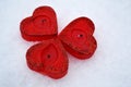 Three red hearts - candles on white snow, a gift for loved ones. Royalty Free Stock Photo