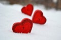 Three red hearts - candles on white snow, a gift for loved ones.