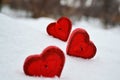 Three red hearts - candles on white snow, a gift for loved ones.