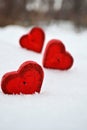 Three red hearts - candles on white snow, a gift for loved ones. Royalty Free Stock Photo