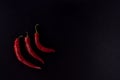 Three red hot chili peppers on black background Royalty Free Stock Photo