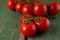 Three red juicy tomatoes on board with worn green color Royalty Free Stock Photo