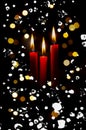 Three red lit candles with colorful bokeh background with spots and snow flakes Royalty Free Stock Photo