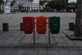 three red, orange, green trash cans