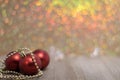 Three red ornaments on board golden bokeh for holiday sale, Christmas background copy spacepace Royalty Free Stock Photo