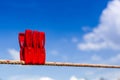 Three red plastic clothespins hang on a laundry line and bright Royalty Free Stock Photo