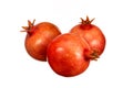 Three red pomegranates are sitting on a white background Royalty Free Stock Photo