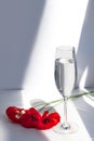 Three red poppy flowers on white table with contrast sun light and shadows and wine glass with water closeup Royalty Free Stock Photo