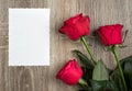 Three red roses and blank sheet on wood Royalty Free Stock Photo