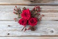 Three red roses in a cluster on rustic wood background Royalty Free Stock Photo