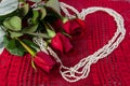 Three Red Roses and Pearls in the sharpe of a heart Royalty Free Stock Photo