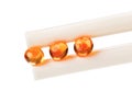 Three red salmon caviar ball in chopsticks